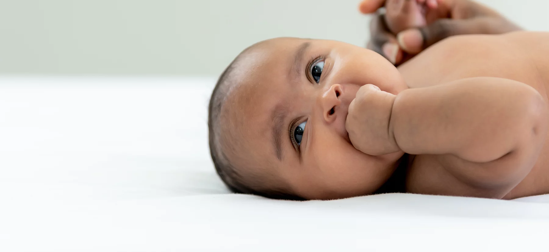 newborn baby with their hand in their mouth. Lactation consultant testimonials.